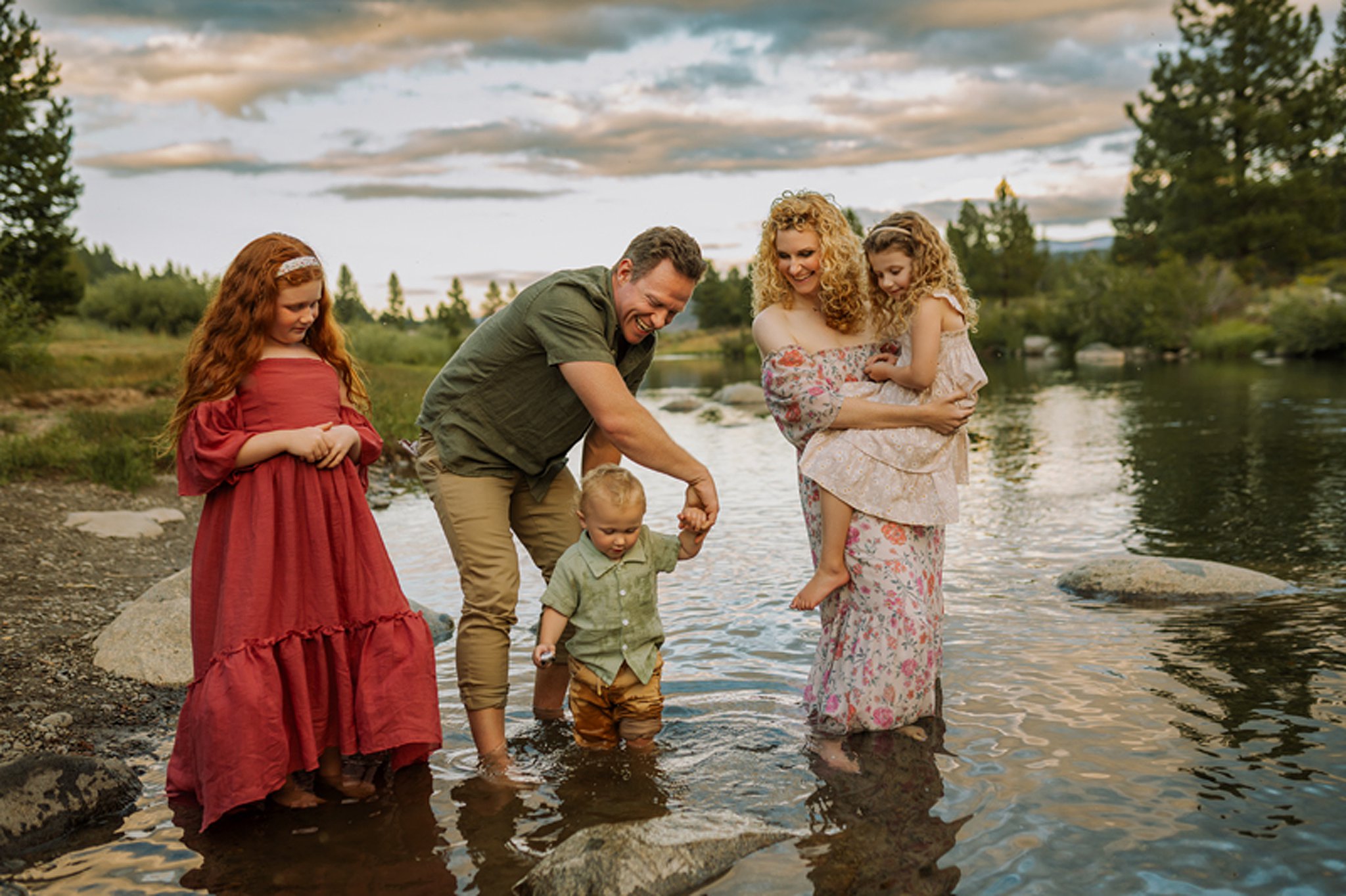 A family of five play in a shallow stream at sunset during kid friendly things to do in reno